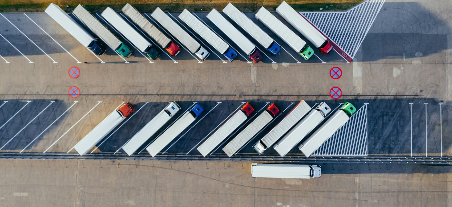 Articulated trucks parked in marked bays, seen from above.
